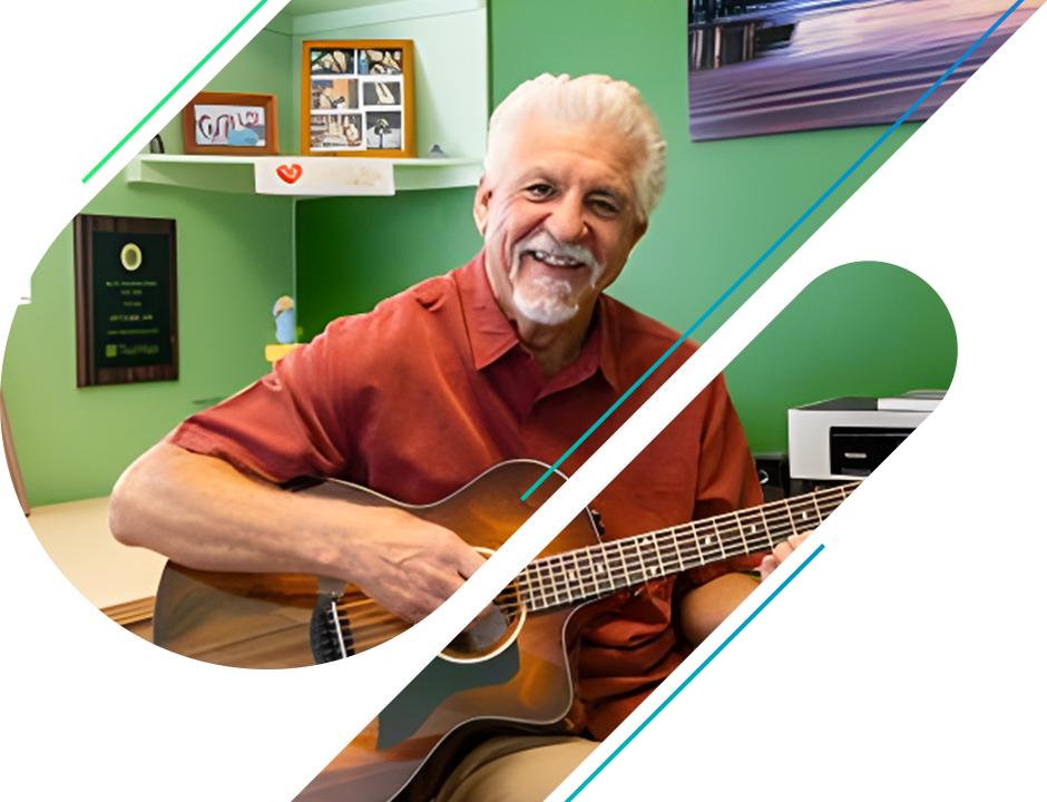 A man playing an instrument in front of a green wall.